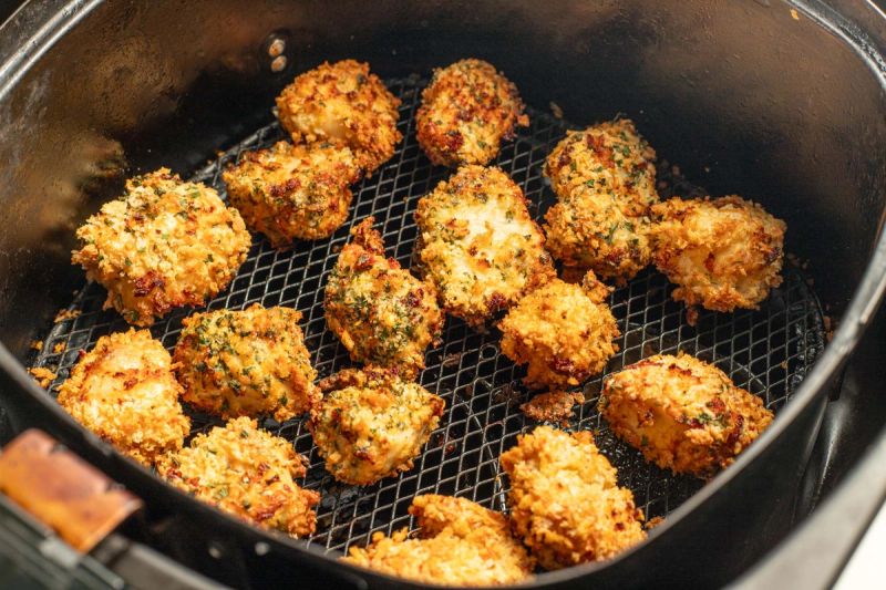 Air fried chicken pieces in air fryer basket Air fried chicken pieces in air fryer basket