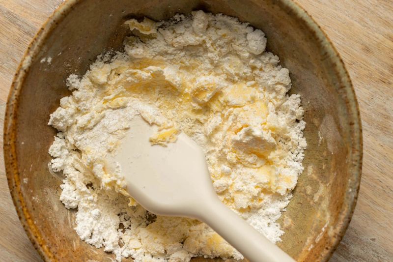 Scraping butter and icing sugar together in a bowl Scraping butter and icing sugar together in a bowl