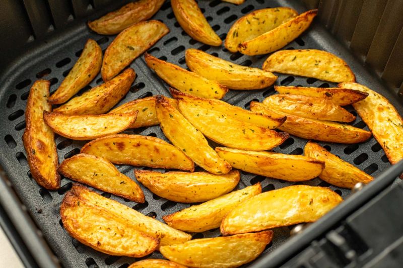 Air fried potato wedges in air fryer basket Air fried potato wedges in air fryer basket