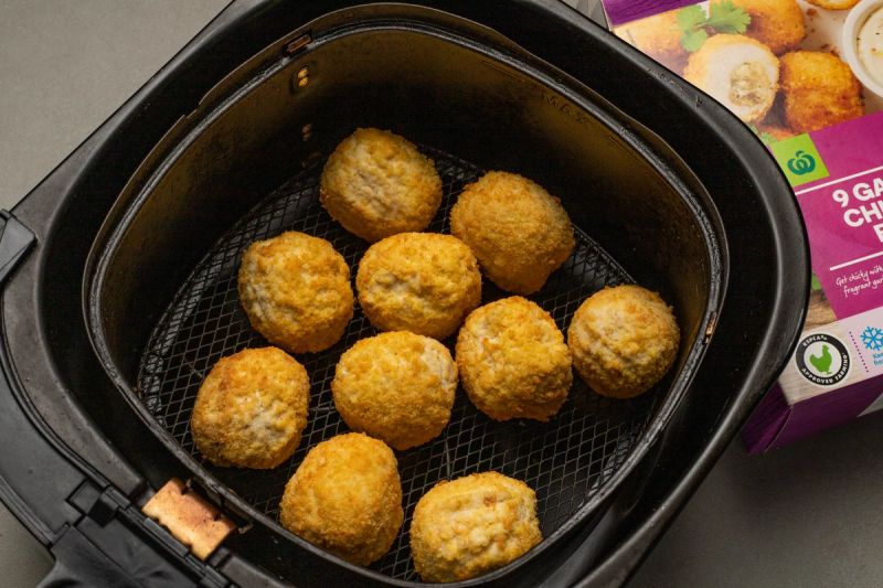 Frozen chicken balls in air fryer basket Frozen chicken balls in air fryer basket
