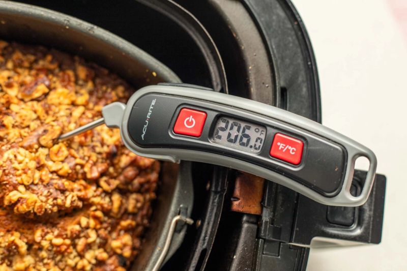 Checking temperature of banana bread with a thermometer Checking temperature of banana bread with a thermometer