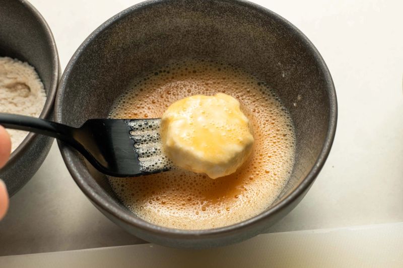 Dipping goats cheese in egg