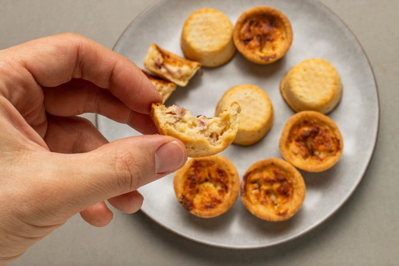 Holding half a mini quiche