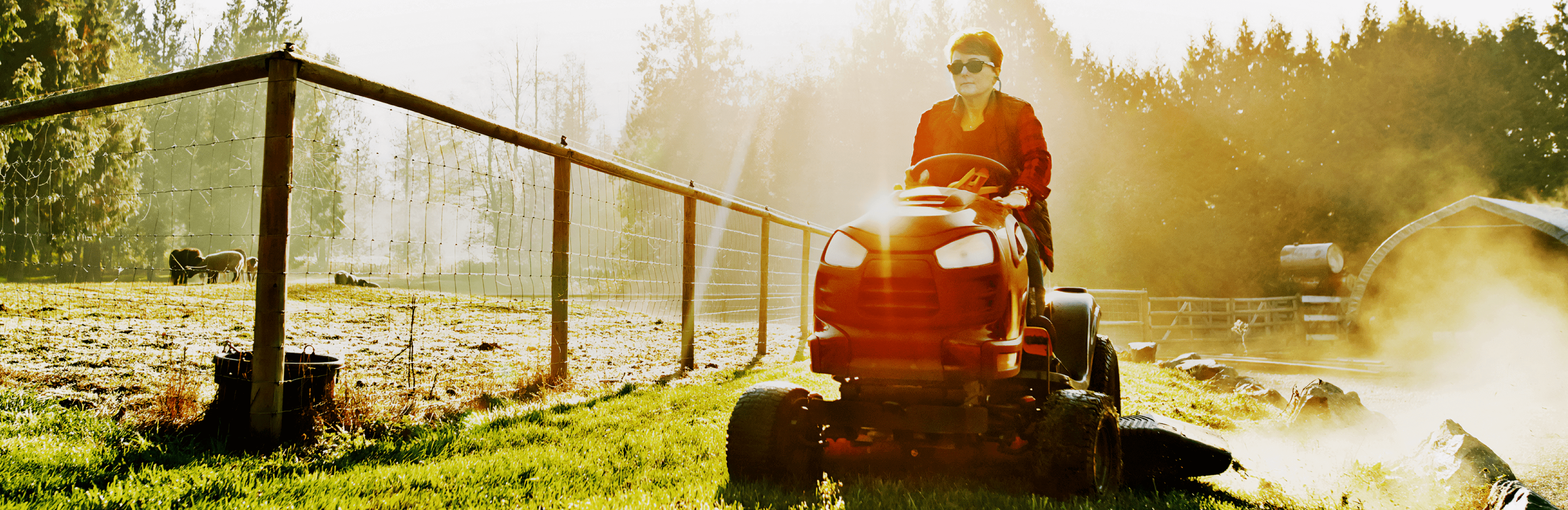 Picture of woman driving a lawnmower in farm setting 