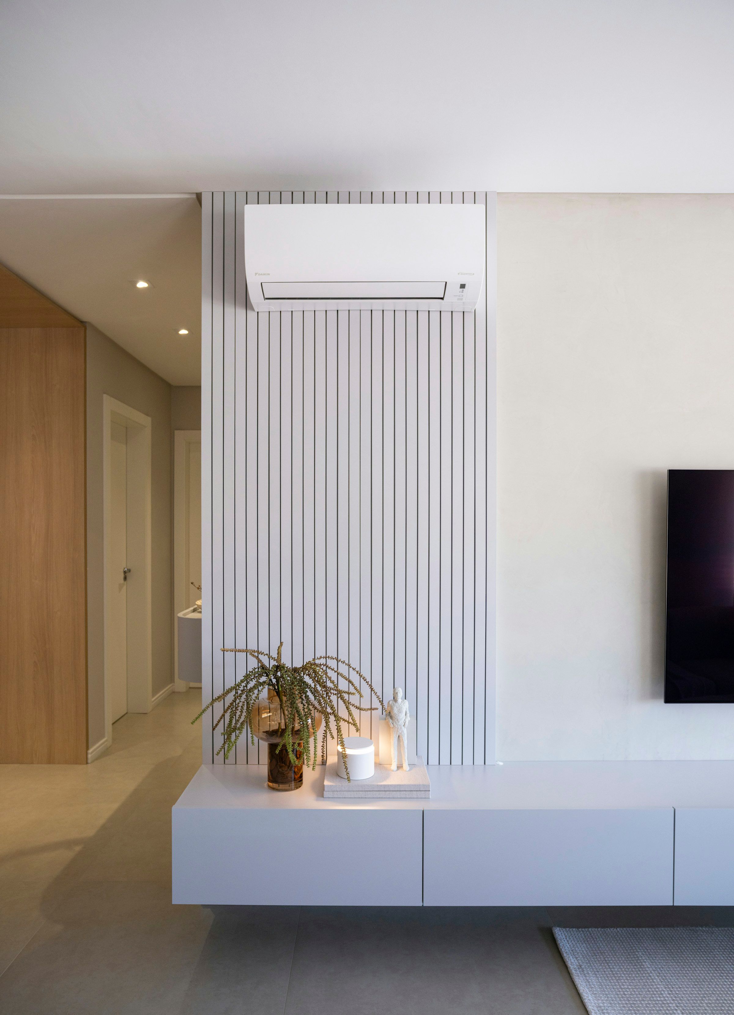 Split-system air conditioner mounted on a feature wall in a modern living room