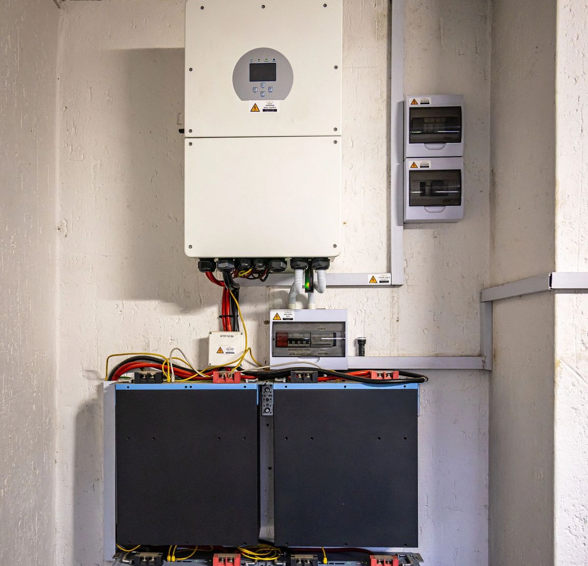 Home solar battery storage system with inverter installed on an interior wall