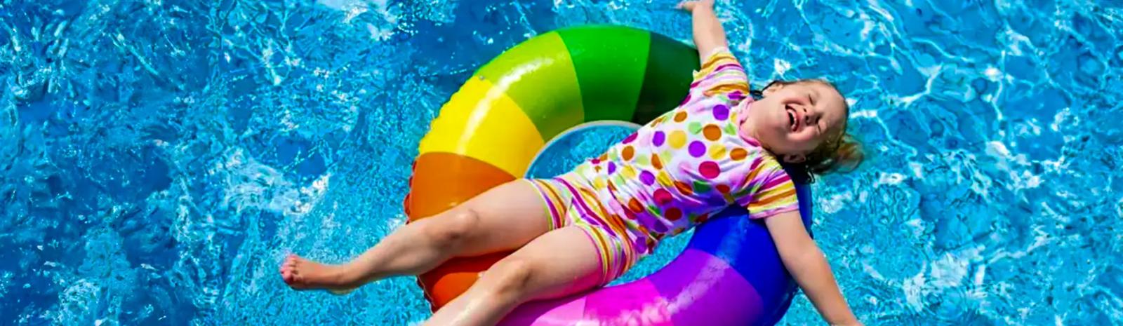 66732341978186c6b741a35f happy little girl on inflatable donut floating on swimming pool ultraWide