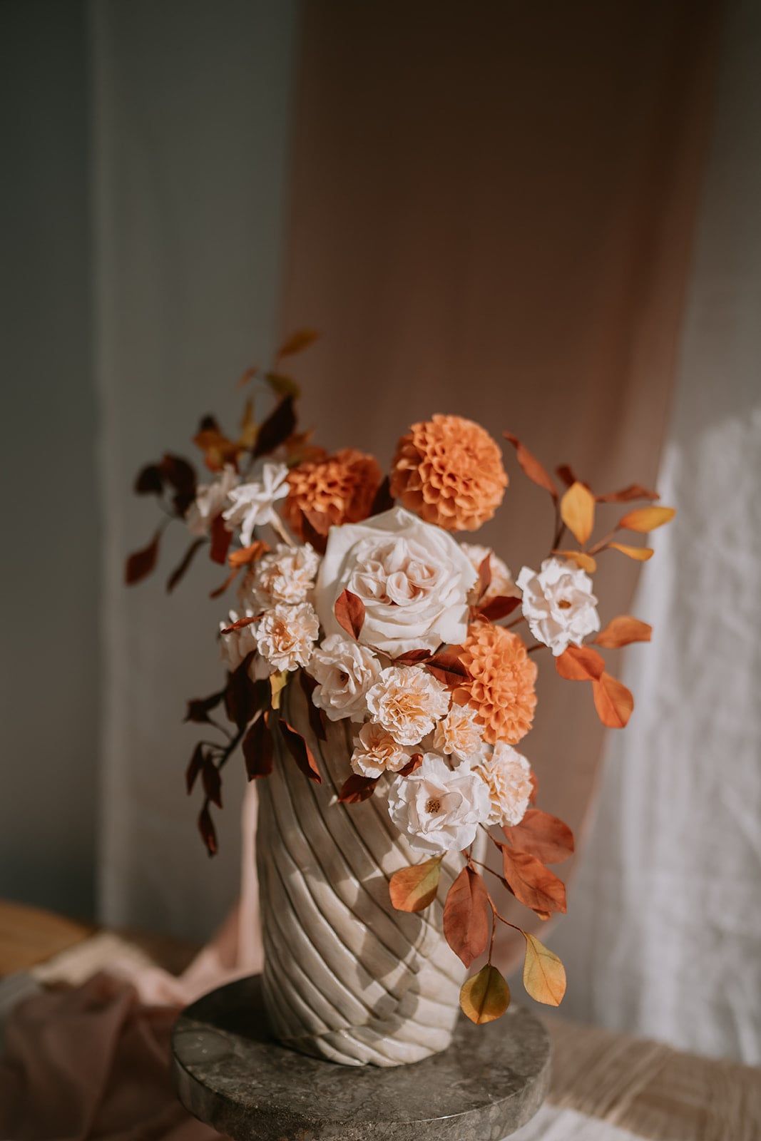 A tall, single-tier round cake with a sculptural, textured buttercream finish, featuring a
