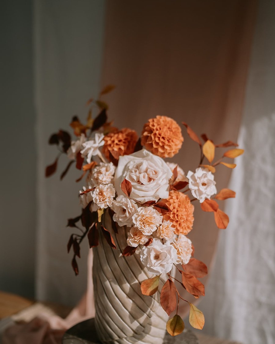 A tall, single-tier round cake with a sculptural, textured buttercream finish, featuring a
