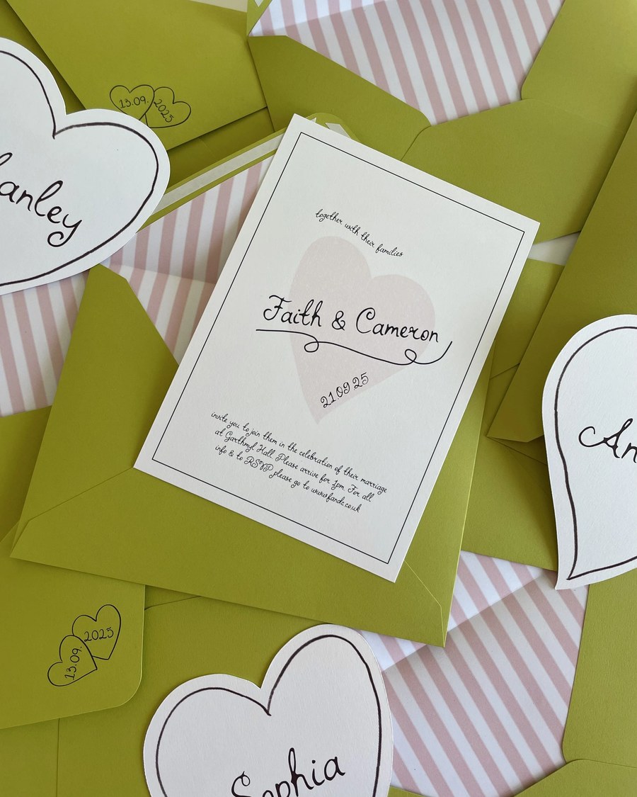 A playful and whimsical invitation suite featuring a central invitation with a delicate pink heart