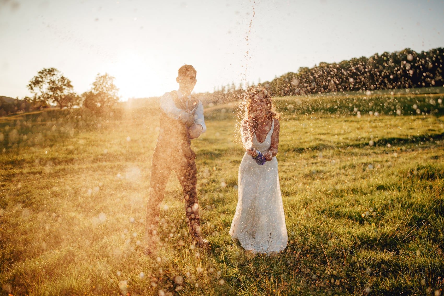 A newlywed couple, the groom in a waistcoat and shirt, and the bride in a white dress, are captured