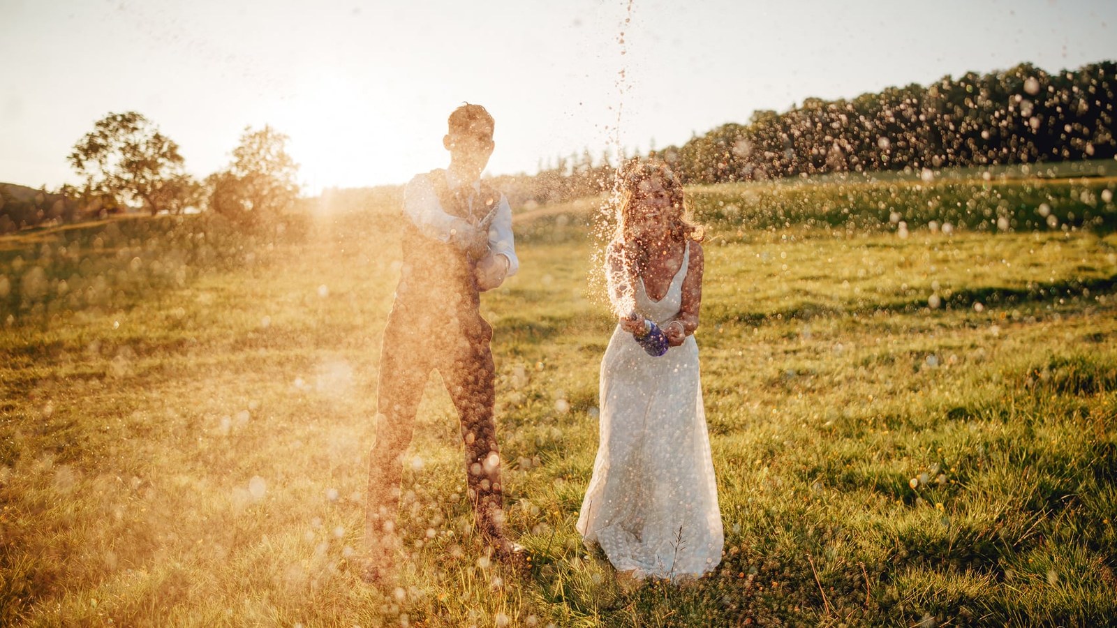A newlywed couple, the groom in a waistcoat and shirt, and the bride in a white dress, are captured