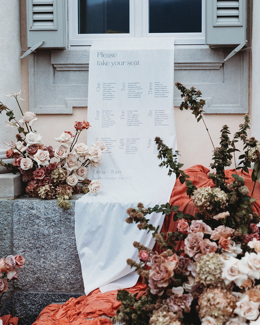 A minimalist and clean wedding table plan in a signage display, featuring a white background with