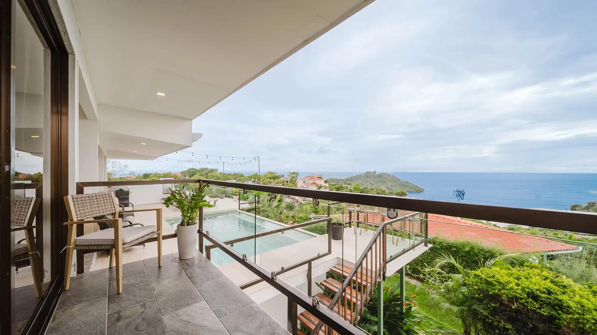 Covered balcony at Casa Grande Vista overlooking the pool deck and Pacific coastline