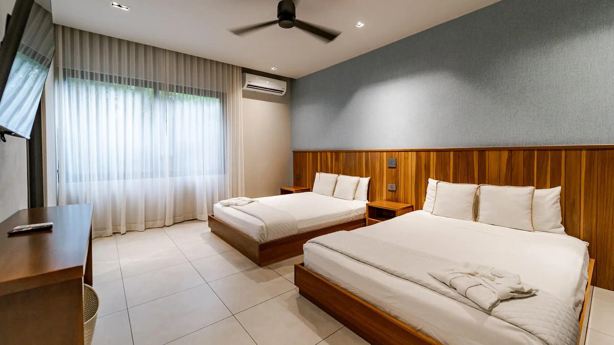Bedroom at Casa Blue Marlin with two beds against a teak plank headboard