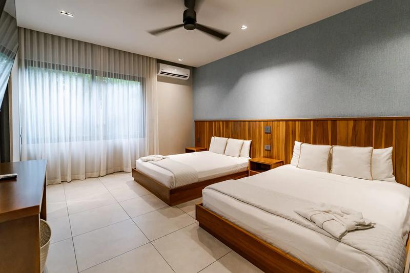 Bedroom at Casa Blue Marlin with two beds against a teak plank headboard
