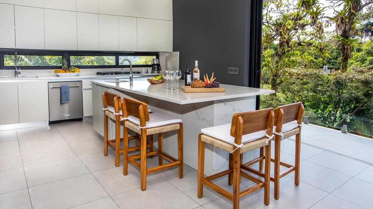 Kitchen island at Casa Nueva Vida with teak bar stools and wine on the counter