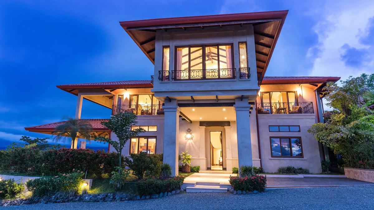 Front entrance of Villa Marbella at dusk with columns and lit balconies