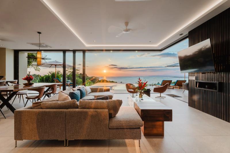 Casa Nola living room at sunset, the whole wall open to the terrace and ocean