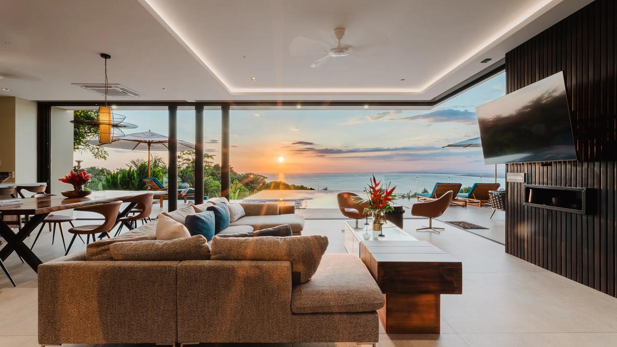 Casa Nola living room at sunset, the whole wall open to the terrace and ocean