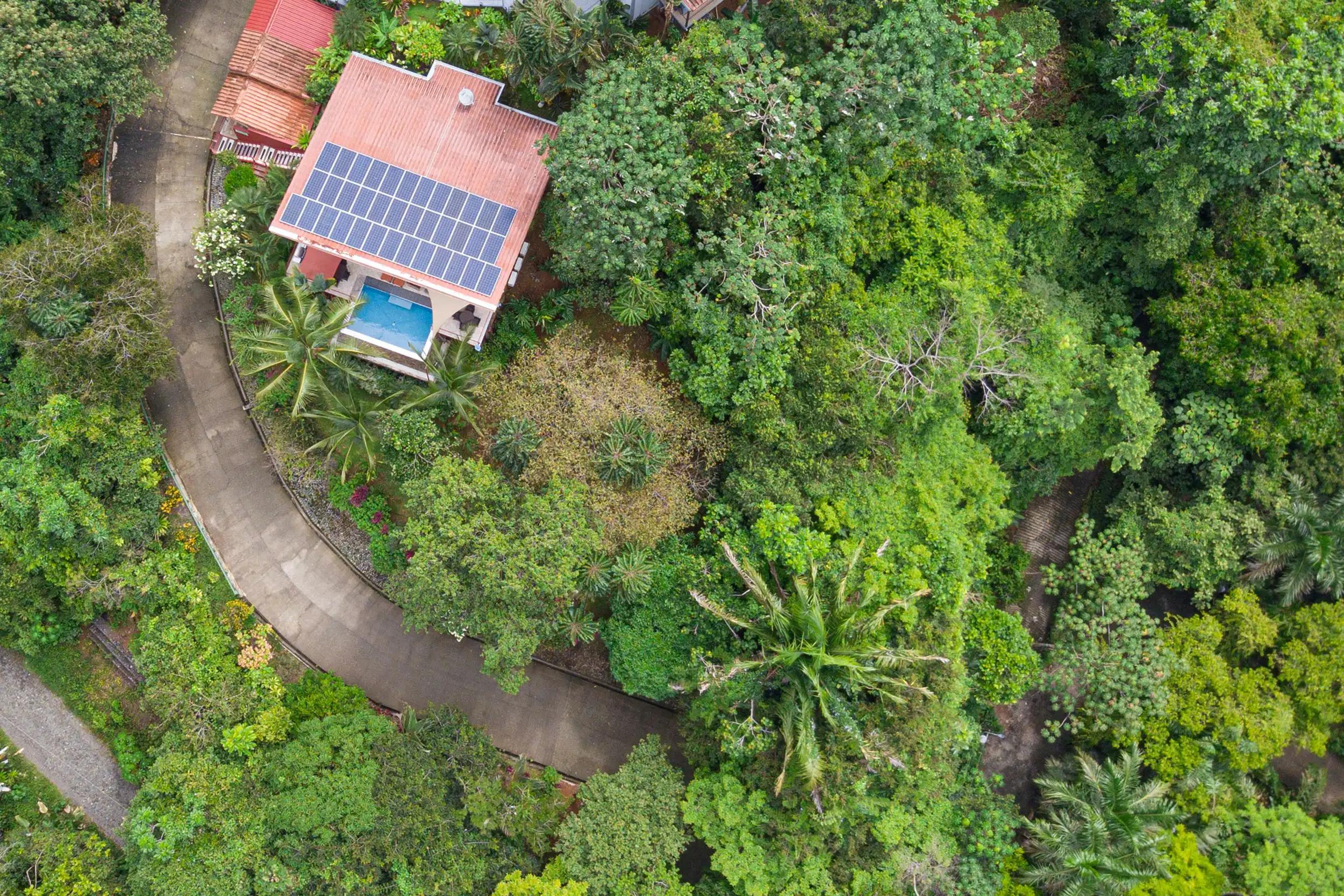 Overhead view of Casa Serenidad showing solar roof, pool, and winding jungle driveway