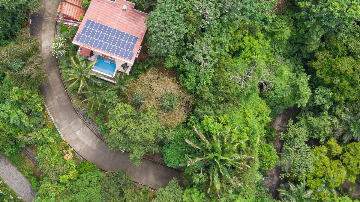 Overhead view of Casa Serenidad showing solar roof, pool, and winding jungle driveway