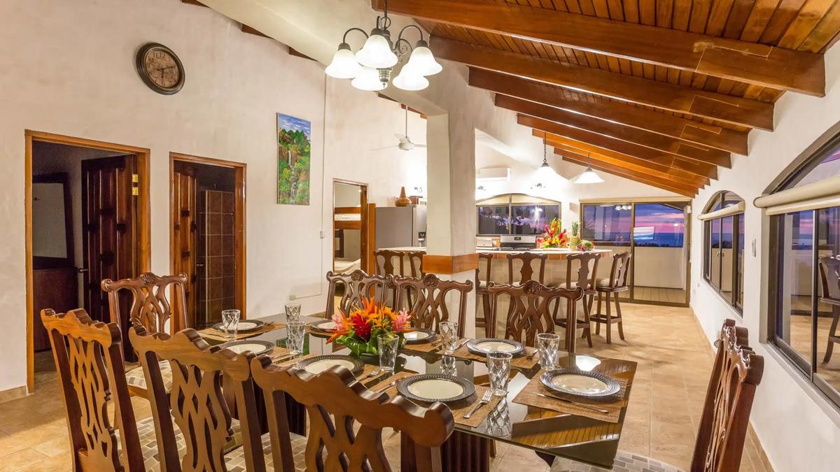 Dining table set for eight at Casa Moreno with kitchen bar beyond