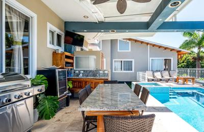 Covered outdoor kitchen and granite dining table beside the pool at Casa Alta Vista