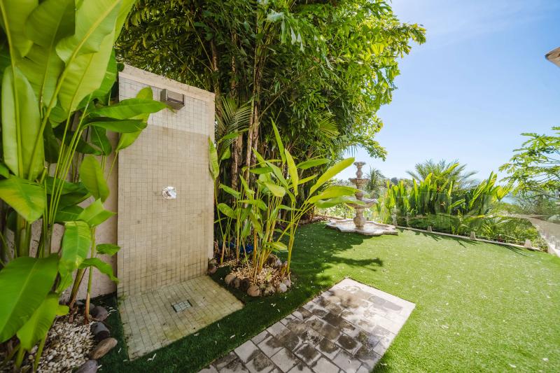 Outdoor rain shower at Casa Nola set in a lawn among heliconias and palms