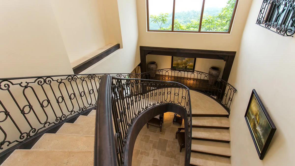 Looking down the curved iron staircase to the foyer of Villa Marbella