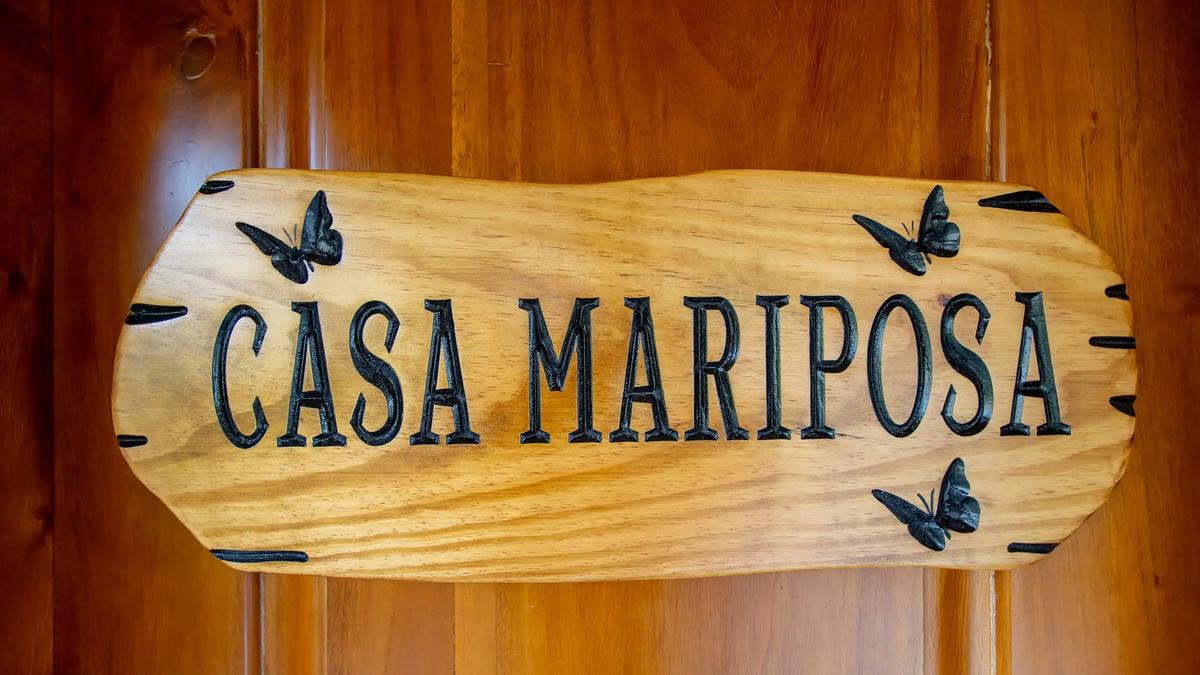 Carved wooden Casa Mariposa sign decorated with black butterflies