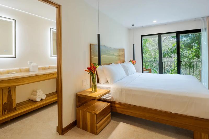 Bedroom with ensuite vanity and jungle facing balcony at Casa Dos Cascadas