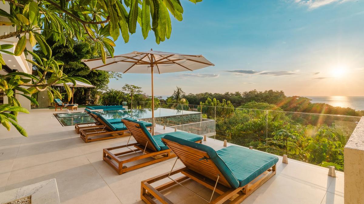 Sunset over the Pacific from Casa Nola's pool terrace, loungers in the last light