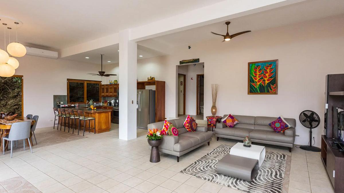 Living room at Casa Pura Paz with leather sofas, zebra print rug, and heliconia painting