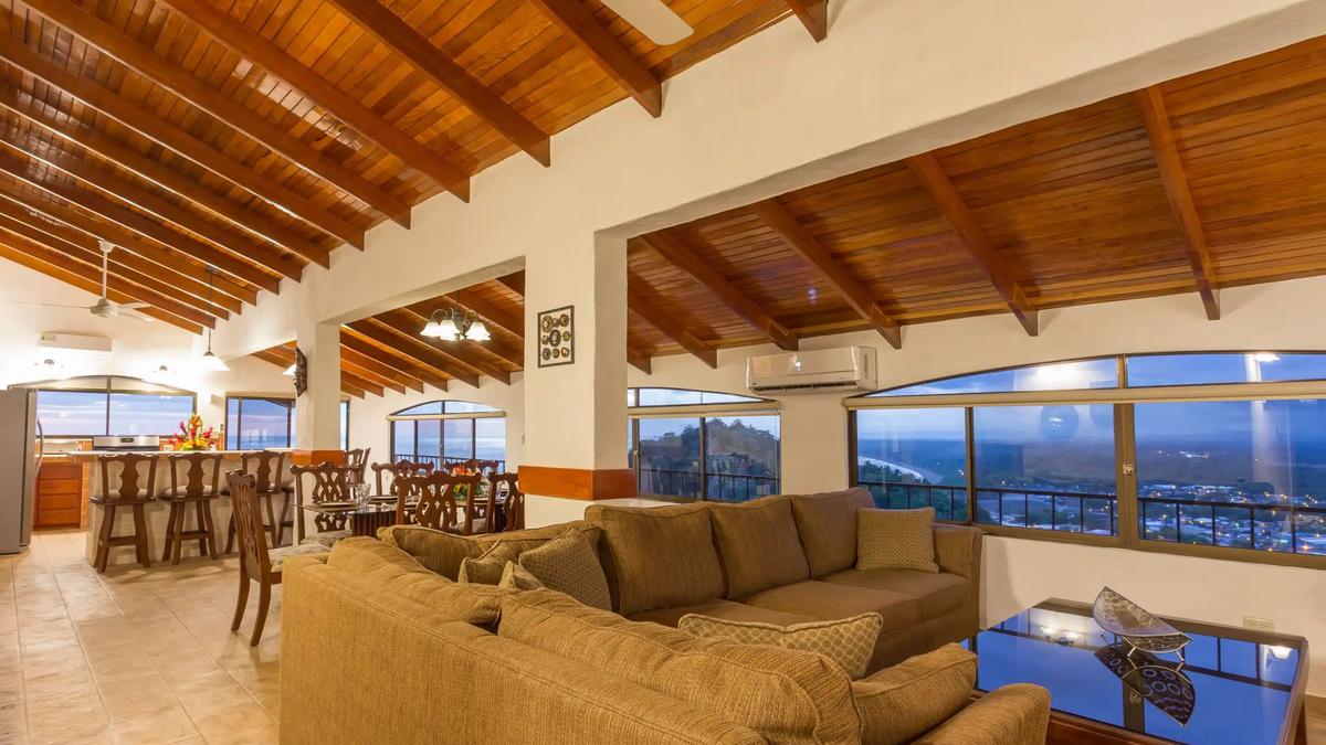 Open plan living room at Casa Moreno with wood beamed ceiling and coastal views