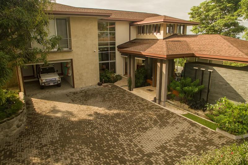 Paver driveway, covered carport, and landscaped entry at Casa Contee