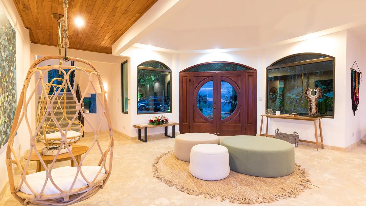 Foyer at Casa Anjali with a hanging rattan chair and carved double doors