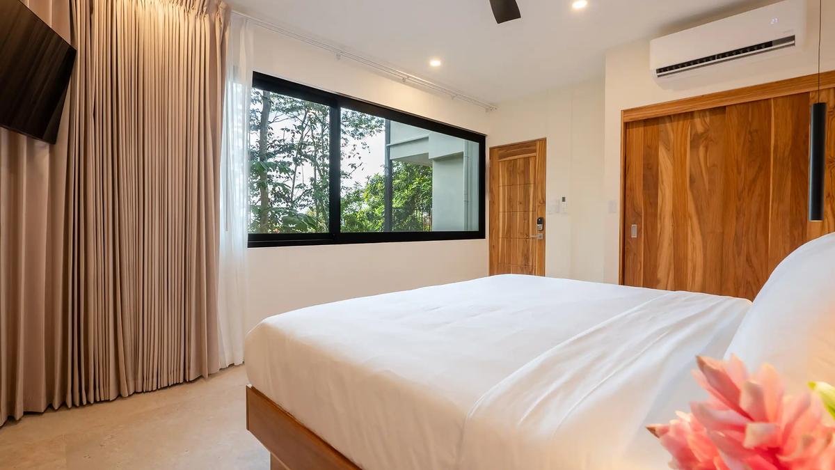 King bedroom with full length curtains and teak doors at Casa Dos Cascadas