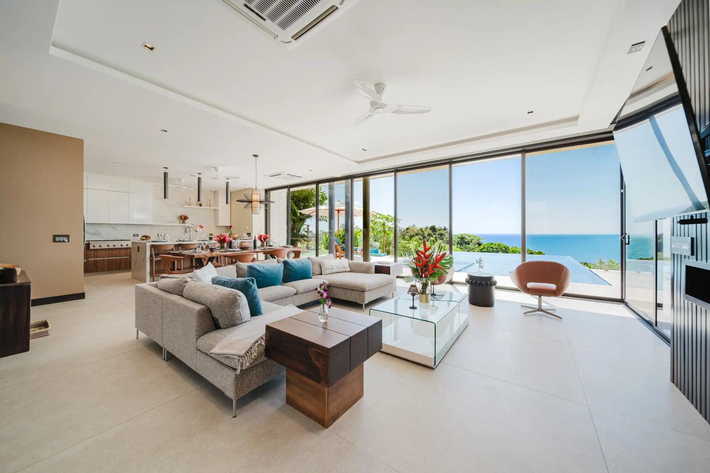 Casa Nola living room with gray sectional opening to the pool and Pacific Ocean