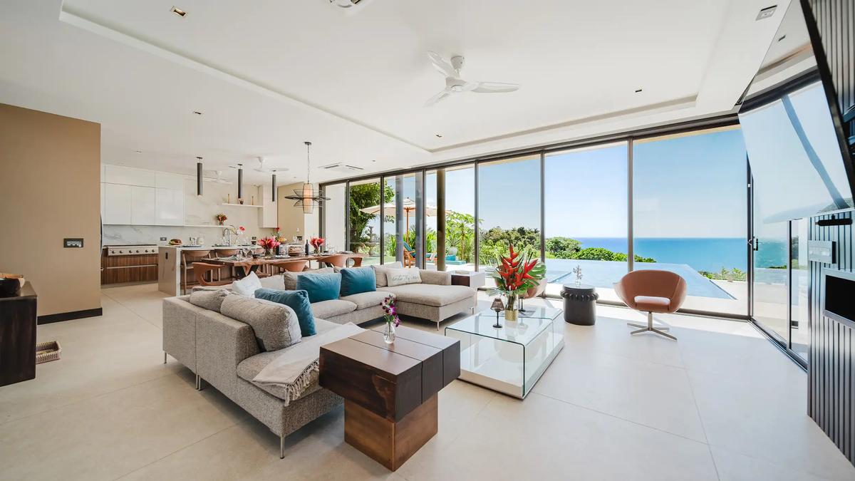 Casa Nola living room with gray sectional opening to the pool and Pacific Ocean