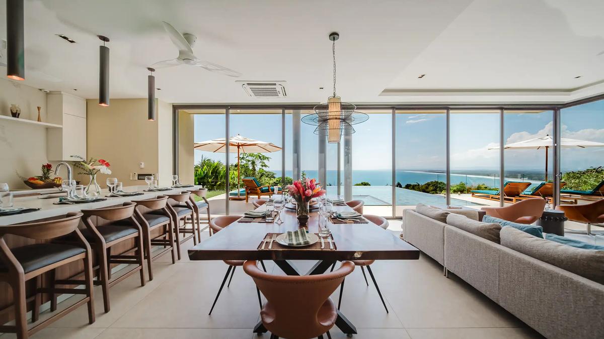 Open dining area at Casa Nola with live edge table and sweeping coastline views