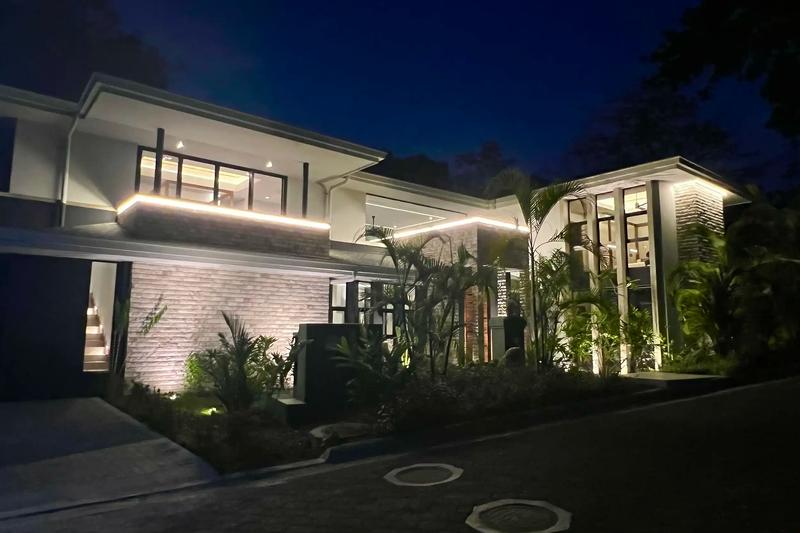 Night view of Villa de Grace with accent lighting along the rooflines