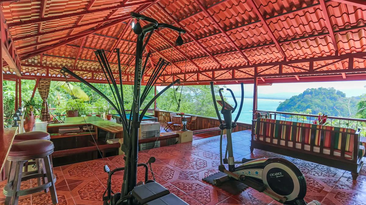 Open air gym at Casa Pura Paz with exercise machines facing the ocean