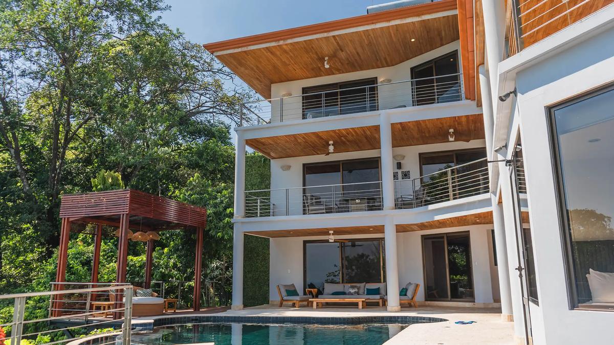 Balconied facade of Casa Anjali rising over the pool terrace in daylight