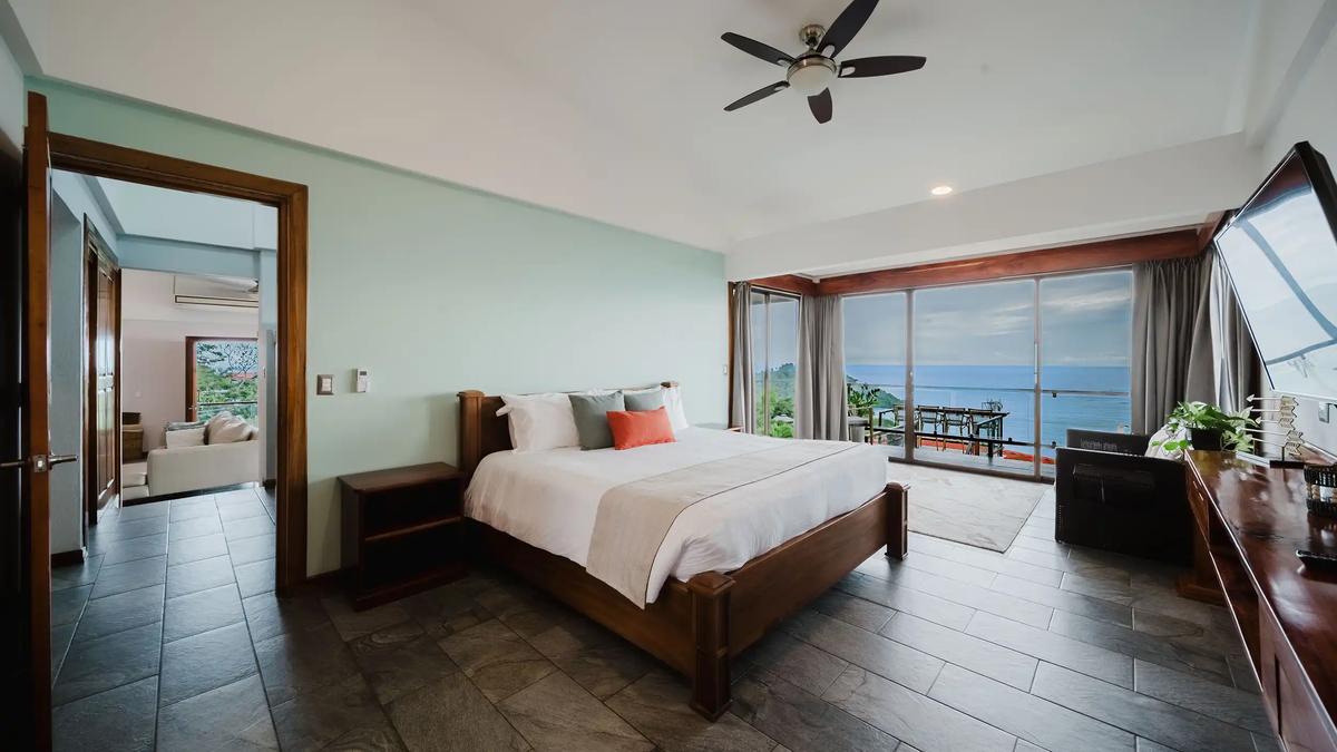 Master bedroom at Casa Grande Vista with glass doors to an ocean view terrace