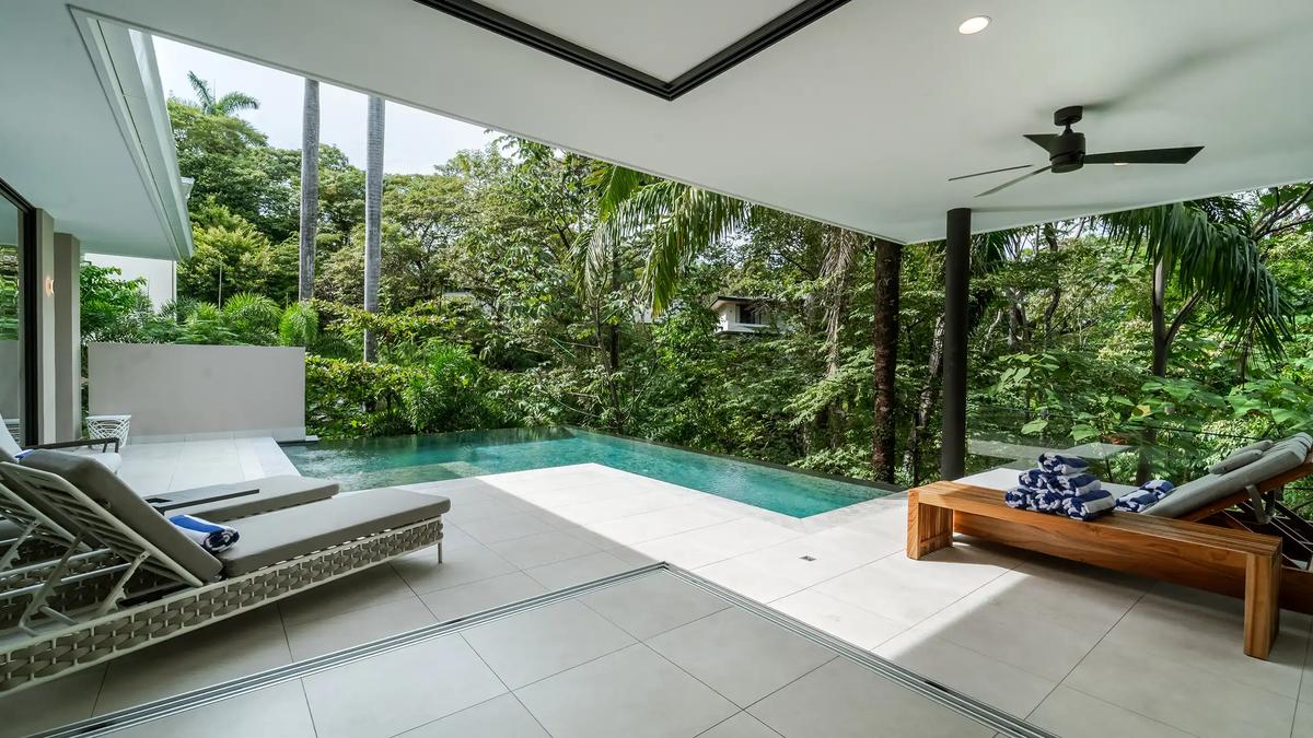 Covered terrace at Casa Blue Marlin with loungers beside the infinity pool