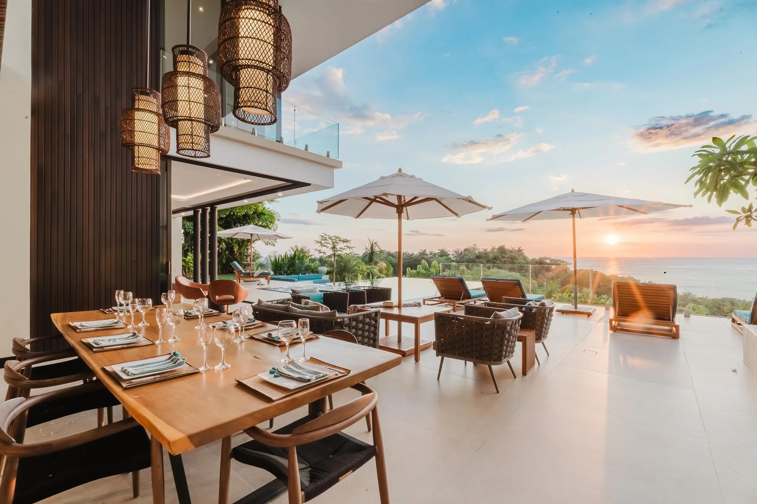 Dinner table set on the Casa Nola terrace as the sun goes down over the sea