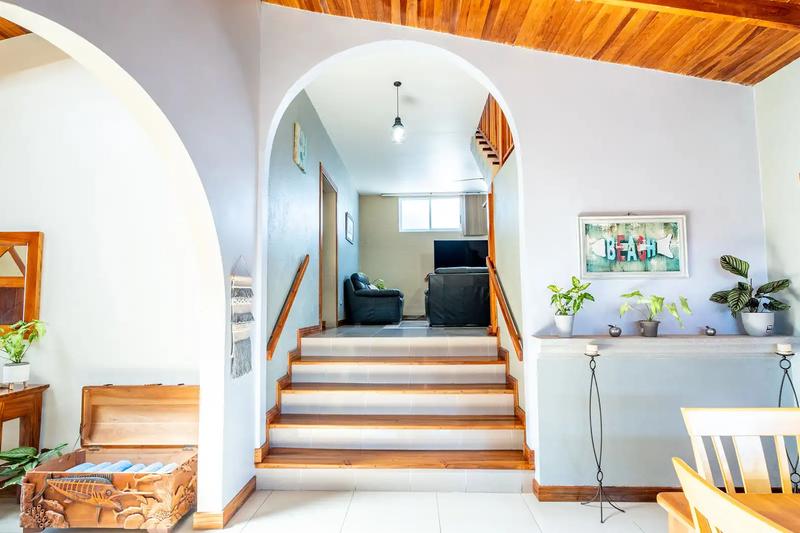 Arched entry hall with stairs leading up to the media lounge at Casa Alta Vista