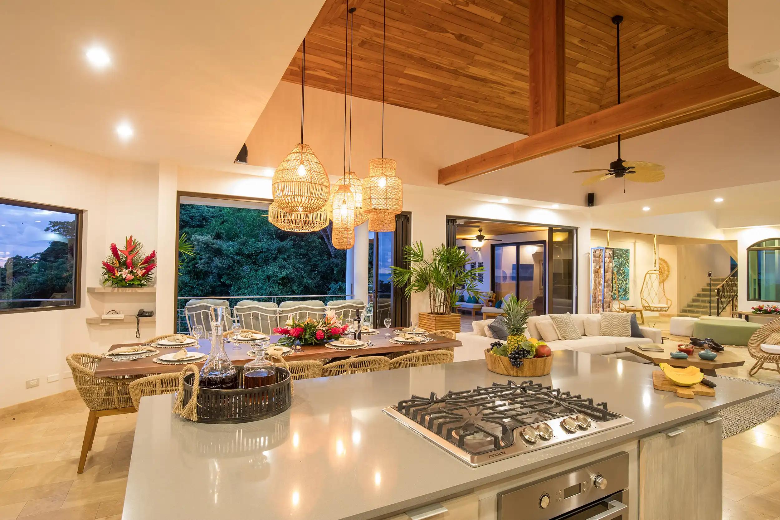 Kitchen island and dining table under woven pendant lights at Casa Anjali