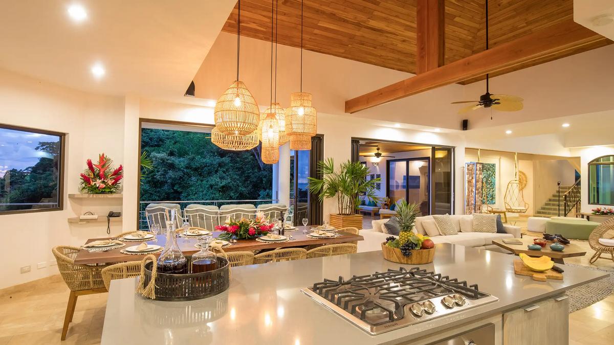 Kitchen island and dining table under woven pendant lights at Casa Anjali